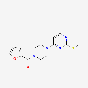 molecular formula C15H18N4O2S B12246186 4-[4-(Furan-2-carbonyl)piperazin-1-yl]-6-methyl-2-(methylsulfanyl)pyrimidine 