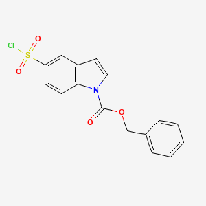 molecular formula C16H12ClNO4S B13227188 Benzyl 5-(chlorosulfonyl)-1H-indole-1-carboxylate 