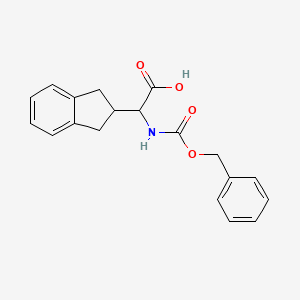 molecular formula C19H19NO4 B1373919 Benzyloxycarbonylamino-indan-2-yl-acetic acid CAS No. 2097068-37-4