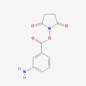 molecular formula C11H10N2O4 B144337 N-(3-氨基苯甲酰氧基)琥珀酰亚胺 CAS No. 132445-63-7