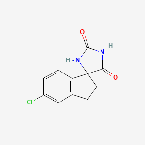 molecular formula C11H9ClN2O2 B1455649 5'-氯-2',3'-二氢螺[咪唑烷-4,1'-茚]-2,5-二酮 CAS No. 351528-73-9