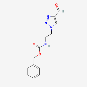 molecular formula C13H14N4O3 B1480651 benzyl (2-(4-formyl-1H-1,2,3-triazol-1-yl)ethyl)carbamate CAS No. 2097965-23-4