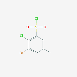 molecular formula C7H5BrCl2O2S B15204135 3-Bromo-2-chloro-5-methylbenzenesulfonyl chloride 