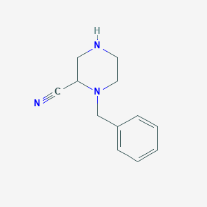 molecular formula C12H15N3 B1525388 1-Benzylpiperazine-2-carbonitrile CAS No. 947726-96-7