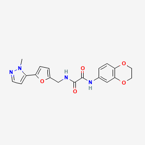 molecular formula C19H18N4O5 B2381837 N'-(2,3-Dihydro-1,4-benzodioxin-6-yl)-N-[[5-(2-methylpyrazol-3-yl)furan-2-yl]methyl]oxamide CAS No. 2415621-97-3