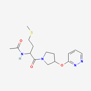 N-(4-(methylthio)-1-oxo-1-(3-(pyridazin-3-yloxy)pyrrolidin-1-yl)butan-2-yl)acetamide