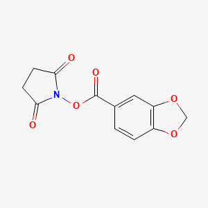 molecular formula C12H9NO6 B2605545 1-[(1,3-Benzodioxol-5-ylcarbonyl)oxy]pyrrolidine-2,5-dione CAS No. 102132-54-7