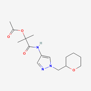 molecular formula C15H23N3O4 B2648629 2-甲基-1-氧代-1-((1-((四氢-2H-吡喃-2-基)甲基)-1H-吡唑-4-基)氨基)丙-2-基乙酸酯 CAS No. 2034529-33-2