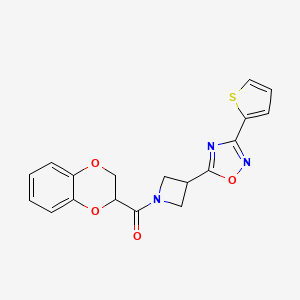 molecular formula C18H15N3O4S B2761670 (2,3-Dihydrobenzo[b][1,4]dioxin-2-yl)(3-(3-(thiophen-2-yl)-1,2,4-oxadiazol-5-yl)azetidin-1-yl)methanone CAS No. 1323792-06-8