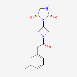 molecular formula C15H17N3O3 B2833300 3-(1-(2-(间甲苯基)乙酰)氮杂环丁烷-3-基)咪唑烷-2,4-二酮 CAS No. 2034432-46-5