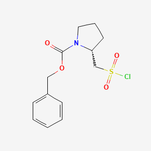 molecular formula C13H16ClNO4S B2854338 benzyl (2R)-2-[(chlorosulfonyl)methyl]pyrrolidine-1-carboxylate CAS No. 1251071-11-0