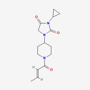molecular formula C15H21N3O3 B2872276 1-{1-[(2E)-but-2-enoyl]piperidin-4-yl}-3-cyclopropylimidazolidine-2,4-dione CAS No. 2097941-10-9