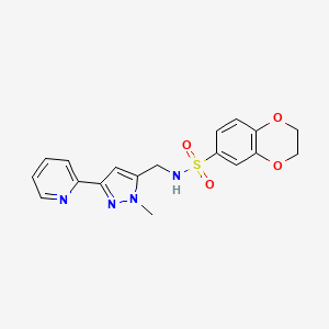 molecular formula C18H18N4O4S B2924118 N-[(2-Methyl-5-pyridin-2-ylpyrazol-3-yl)methyl]-2,3-dihydro-1,4-benzodioxine-6-sulfonamide CAS No. 2319639-89-7