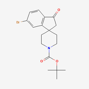 molecular formula C18H22BrNO3 B3086598 tert-Butyl 6-bromo-3-oxo-2,3-dihydrospiro[indene-1,4'-piperidine]-1'-carboxylate CAS No. 1160247-43-7