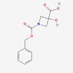 molecular formula C12H13NO5 B3151249 1-[(苄氧羰基)羰基]-3-羟基氮杂环丁烷-3-羧酸 CAS No. 70767-64-5