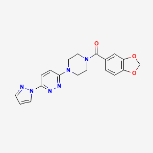 molecular formula C19H18N6O3 B3201050 (4-(6-(1H-pyrazol-1-yl)pyridazin-3-yl)piperazin-1-yl)(benzo[d][1,3]dioxol-5-yl)methanone CAS No. 1019100-78-7