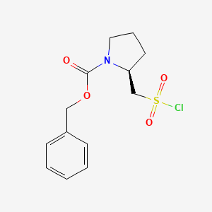 molecular formula C13H16ClNO4S B3380947 (S)-2-Chlorosulfonylmethyl-pyrrolidine-1-carboxylic acid benzyl ester CAS No. 212204-36-9