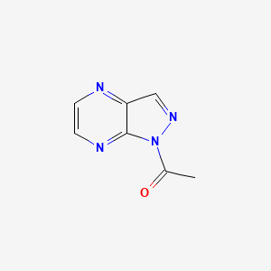 molecular formula C7H6N4O B560999 1-(1H-pyrazolo[3,4-b]pyrazin-1-yl)ethanone CAS No. 19868-87-2