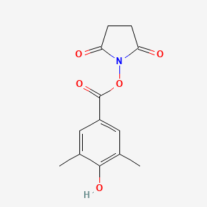 B590533 1-[(4-Hydroxy-3,5-dimethylbenzoyl)oxy]pyrrolidine-2,5-dione CAS No. 158788-56-8