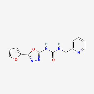 molecular formula C13H11N5O3 B609587 1-[5-(Furan-2-yl)-1,3,4-oxadiazol-2-yl]-3-(pyridin-2-ylmethyl)urea CAS No. 1414963-82-8