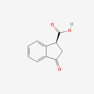 B6617128 (1S)-3-oxo-2,3-dihydro-1H-indene-1-carboxylic acid CAS No. 40985-43-1