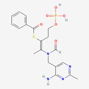 molecular formula C19H23N4O6PS B7790774 S-[(E)-2-[(4-amino-2-methylpyrimidin-5-yl)methyl-formylamino]-5-phosphonooxypent-2-en-3-yl] benzenecarbothioate 