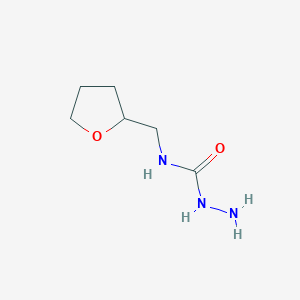 molecular formula C6H13N3O2 B7868564 3-Amino-1-(oxolan-2-ylmethyl)urea 