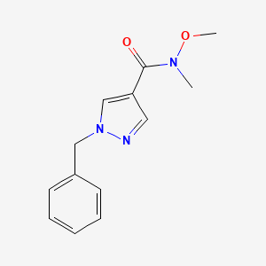 molecular formula C13H15N3O2 B7946539 1-Benzyl-N-methoxy-N-methyl-1H-pyrazole-4-carboxamide 