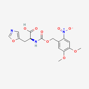 molecular formula C16H17N3O9 B7983632 (S)-2-((((4,5-Dimethoxy-2-nitrobenzyl)oxy)carbonyl)amino)-3-(oxazol-5-yl)propanoic acid 