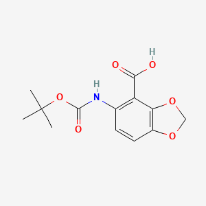 molecular formula C13H15NO6 B8018624 5-[(2-Methylpropan-2-yl)oxycarbonylamino]-1,3-benzodioxole-4-carboxylic acid 