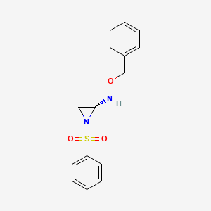 molecular formula C15H16N2O3S B8030251 (R)-O-Benzyl-N-(1-(phenylsulfonyl)aziridin-2-yl)hydroxylamine 