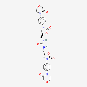 molecular formula C29H32N6O9 B8091056 1-[[2-oxo-3-[4-(3-oxomorpholin-4-yl)phenyl]-1,3-oxazolidin-5-yl]methyl]-3-[[(5S)-2-oxo-3-[4-(3-oxomorpholin-4-yl)phenyl]-1,3-oxazolidin-5-yl]methyl]urea 