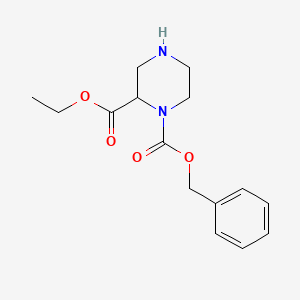 molecular formula C15H20N2O4 B8107454 1-Benzyl 2-ethyl piperazine-1,2-dicarboxylate 