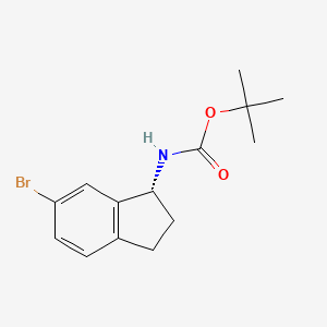 molecular formula C14H18BrNO2 B8148074 (R)-(6-Bromo-indan-1-yl)-carbamic acid tert-butyl ester 