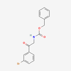molecular formula C16H14BrNO3 B8148446 benzyl N-[2-(3-bromophenyl)-2-oxoethyl]carbamate 