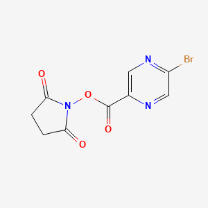 molecular formula C9H6BrN3O4 B8151179 5-Bromo-pyrazine-2-carboxylic acid 2,5-dioxo-pyrrolidin-1-yl ester 