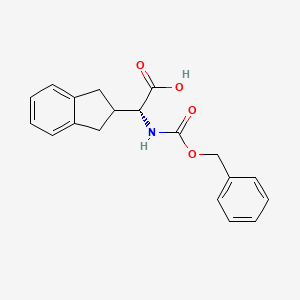 molecular formula C19H19NO4 B8185139 (R)-Benzyloxycarbonylamino-indan-2-yl-acetic acid 