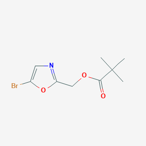 molecular formula C9H12BrNO3 B8188762 2,2-Dimethyl-propionic acid 5-bromo-oxazol-2-ylmethyl ester 