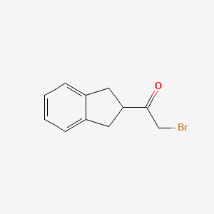 molecular formula C11H11BrO B8469594 2-Bromo-1-indan-2-ylethanone 